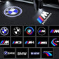 BMW logo projection on a car floor with various BMW logos displayed below.